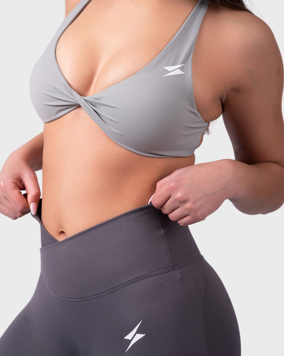 Close-up side angle showing supportive fit and detail on grey sports bra.
