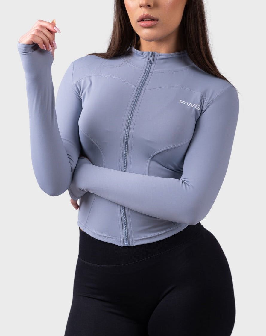 PWG Evolve Sculpt Fit Jacket in Lilac Blue, full zip, high neck, front PWG logo, thumbhole sleeves, breathable fabric - Front View