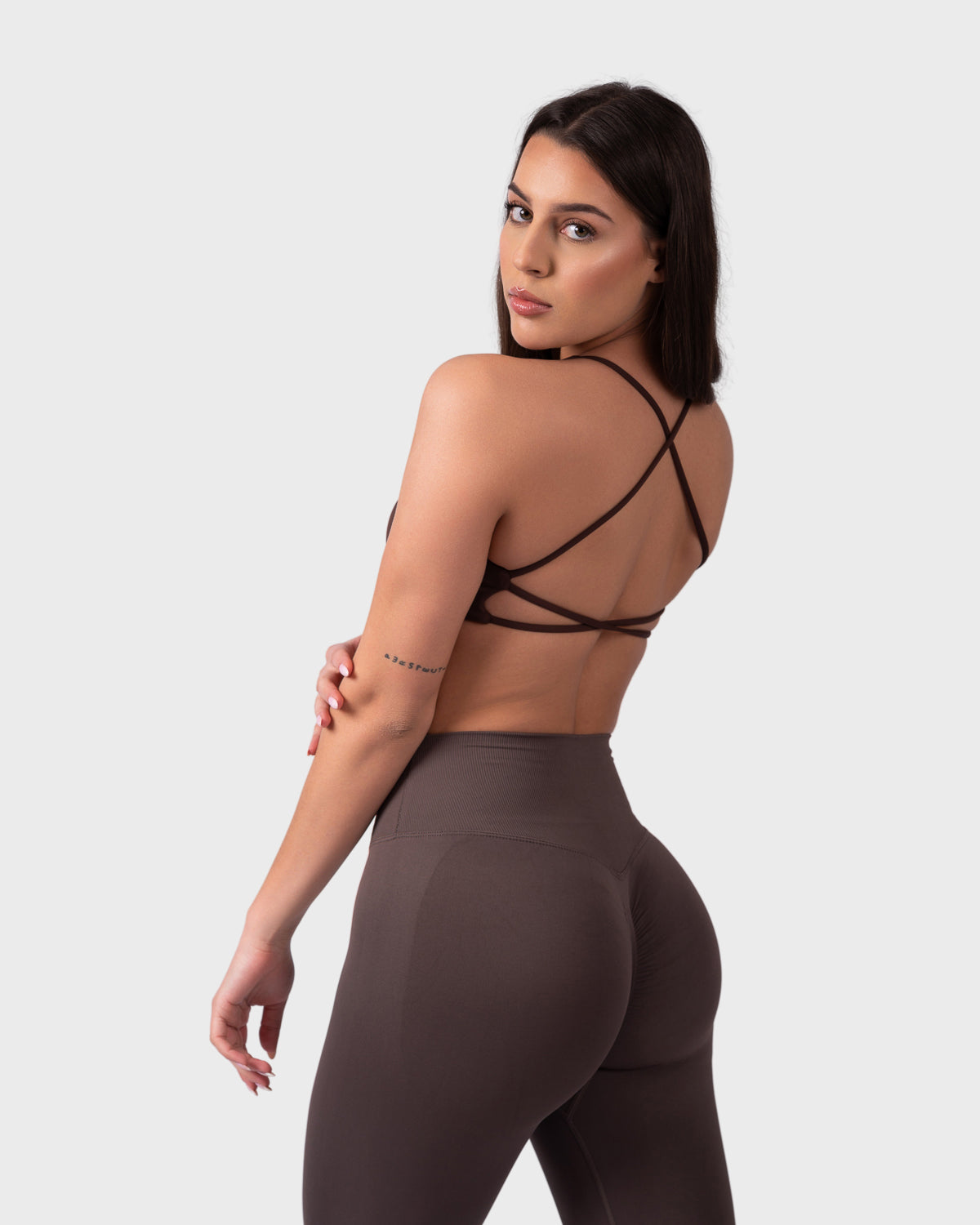 Rear angle showing open-back design with crisscross straps in brown bra.