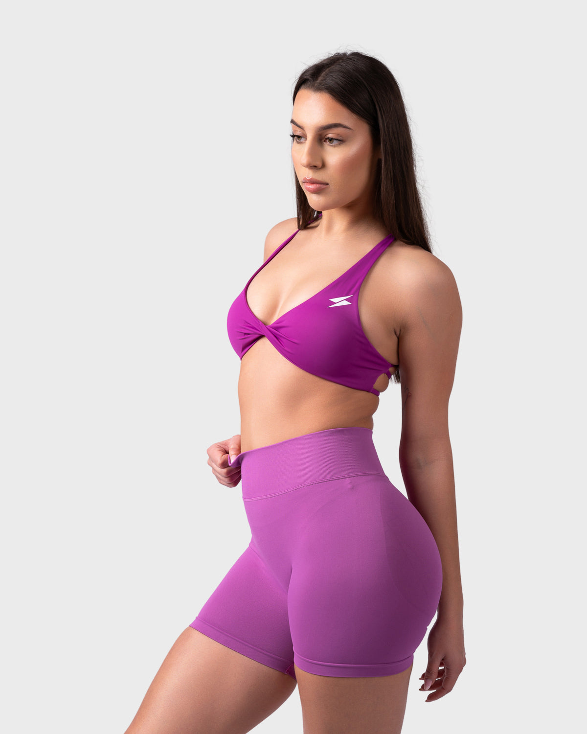 Side angle showing deep neckline and twist-front detail in purple bra.