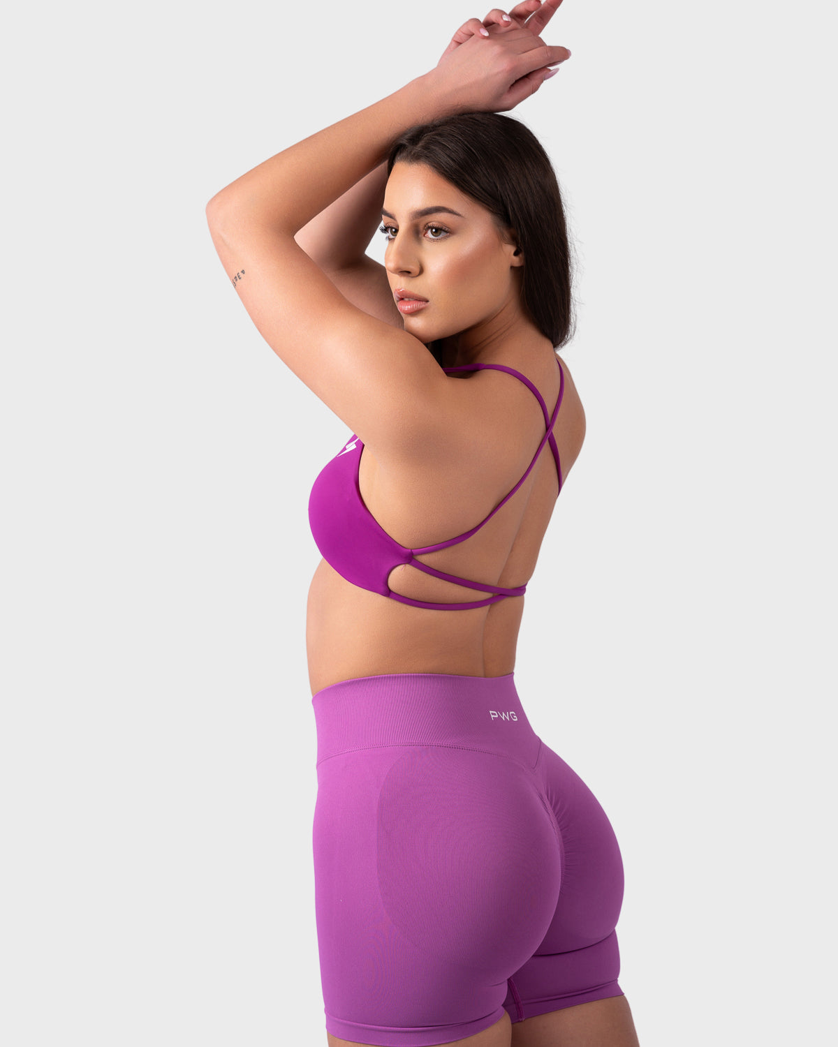 Evolve Backless Sports Bra from PWG Active in bright purple, open back with crisscross straps.