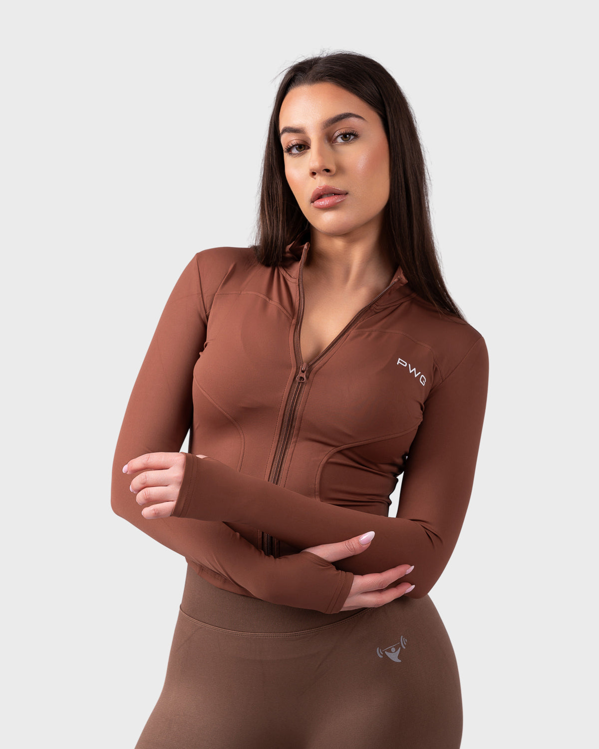 Front pose in chocolate sculpt jacket, arms crossed, styled with matching leggings.