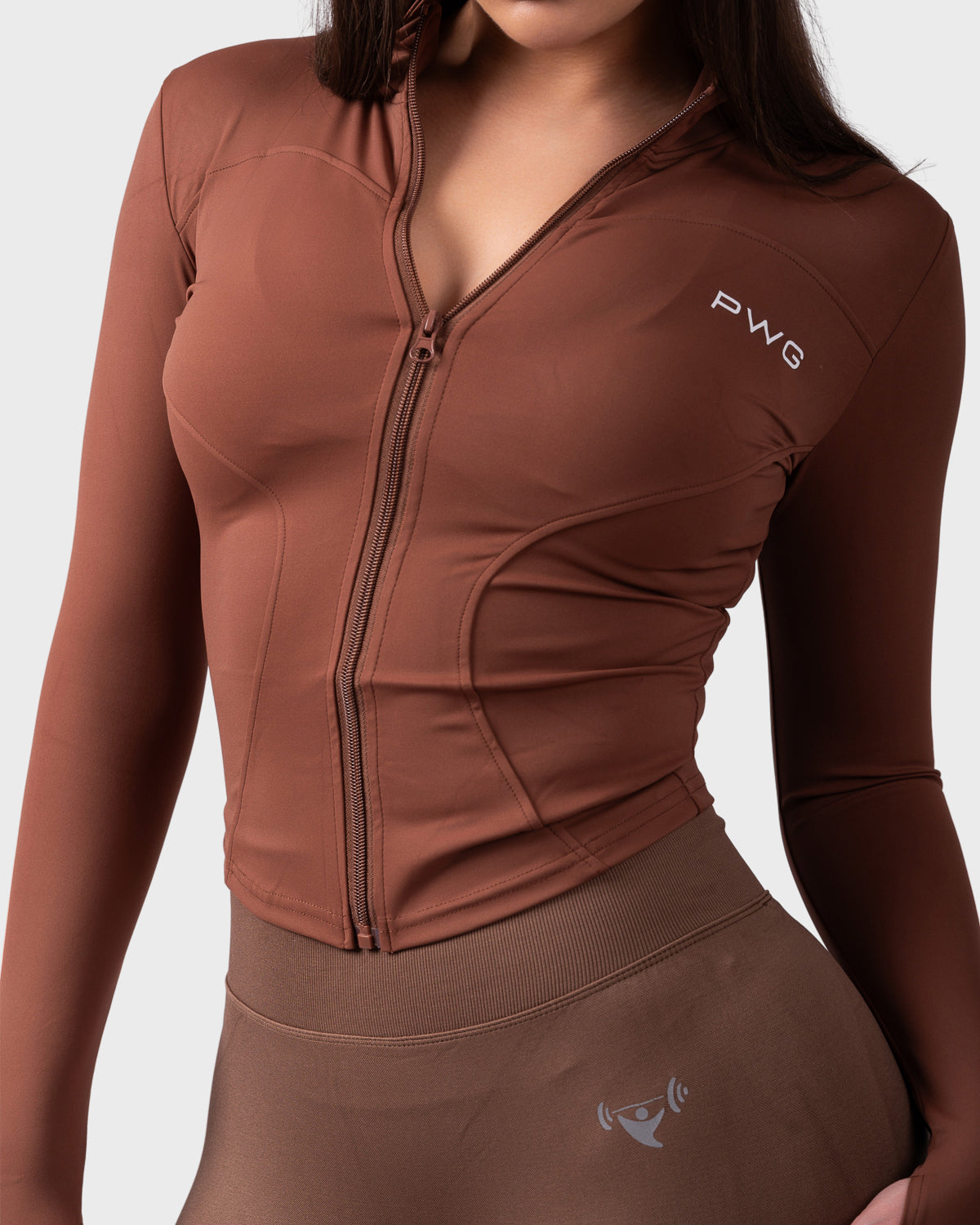 Close-up front detail of chocolate jacket, zipper and chest logo visible.