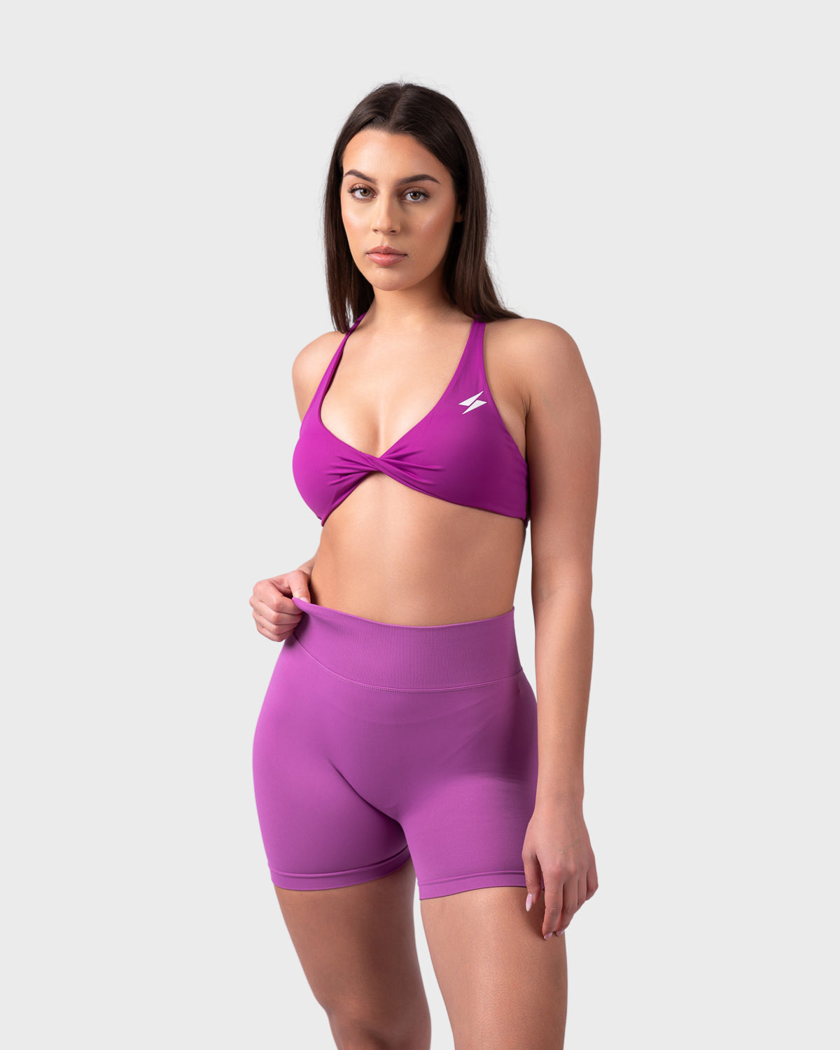 Front view of bright purple backless bra styled with matching sculpting shorts.