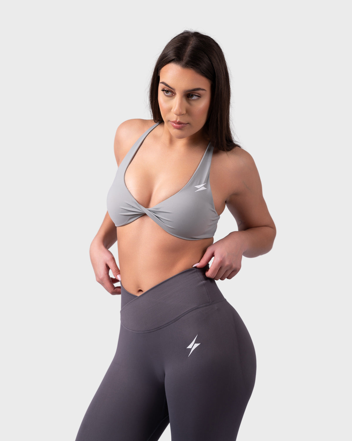 Front pose wearing grey Evolve Backless Bra, styled with matching sculpting leggings.