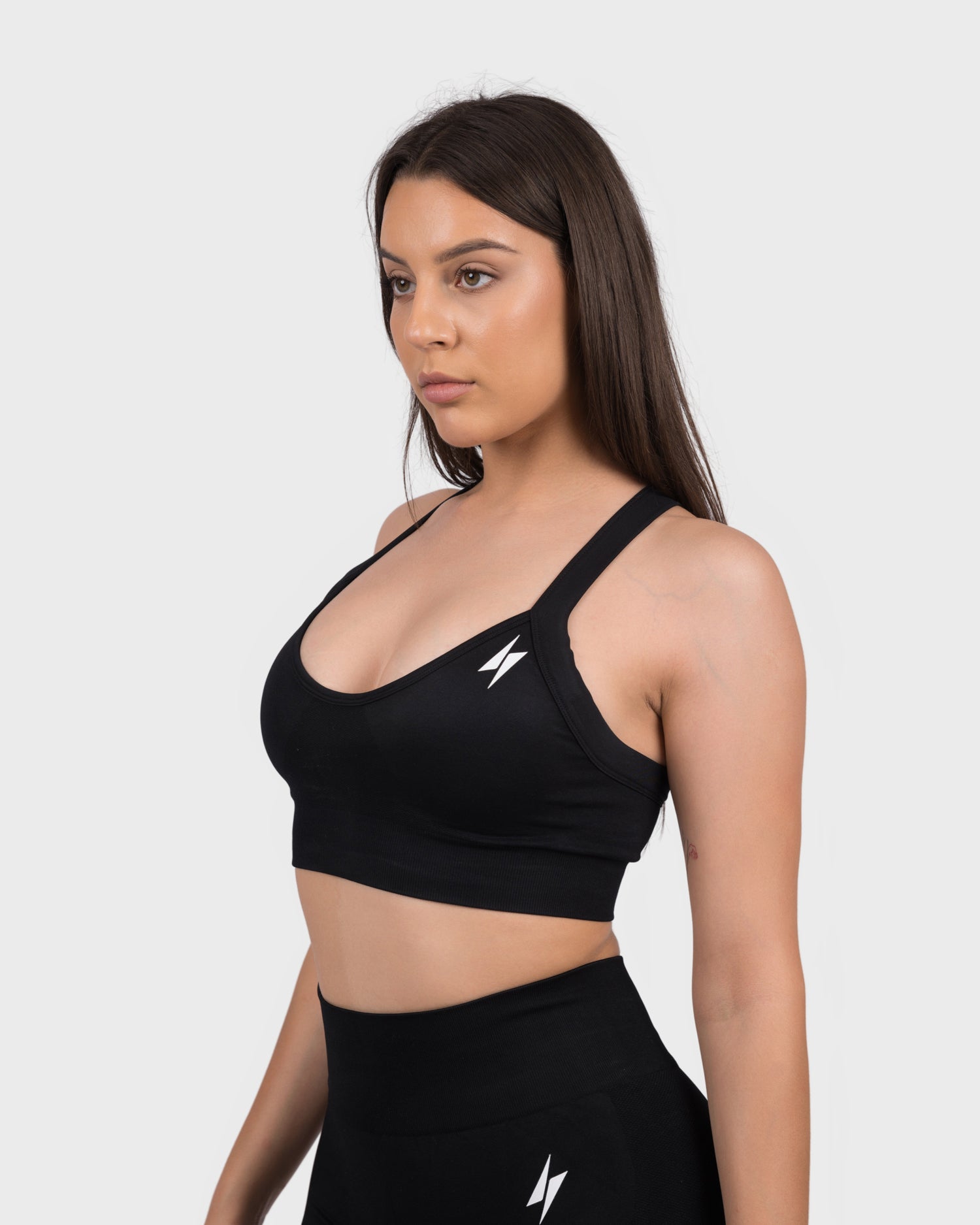 FlexActive Sports Bra from PWG Active in black, scoop neck and logo detail, front view.