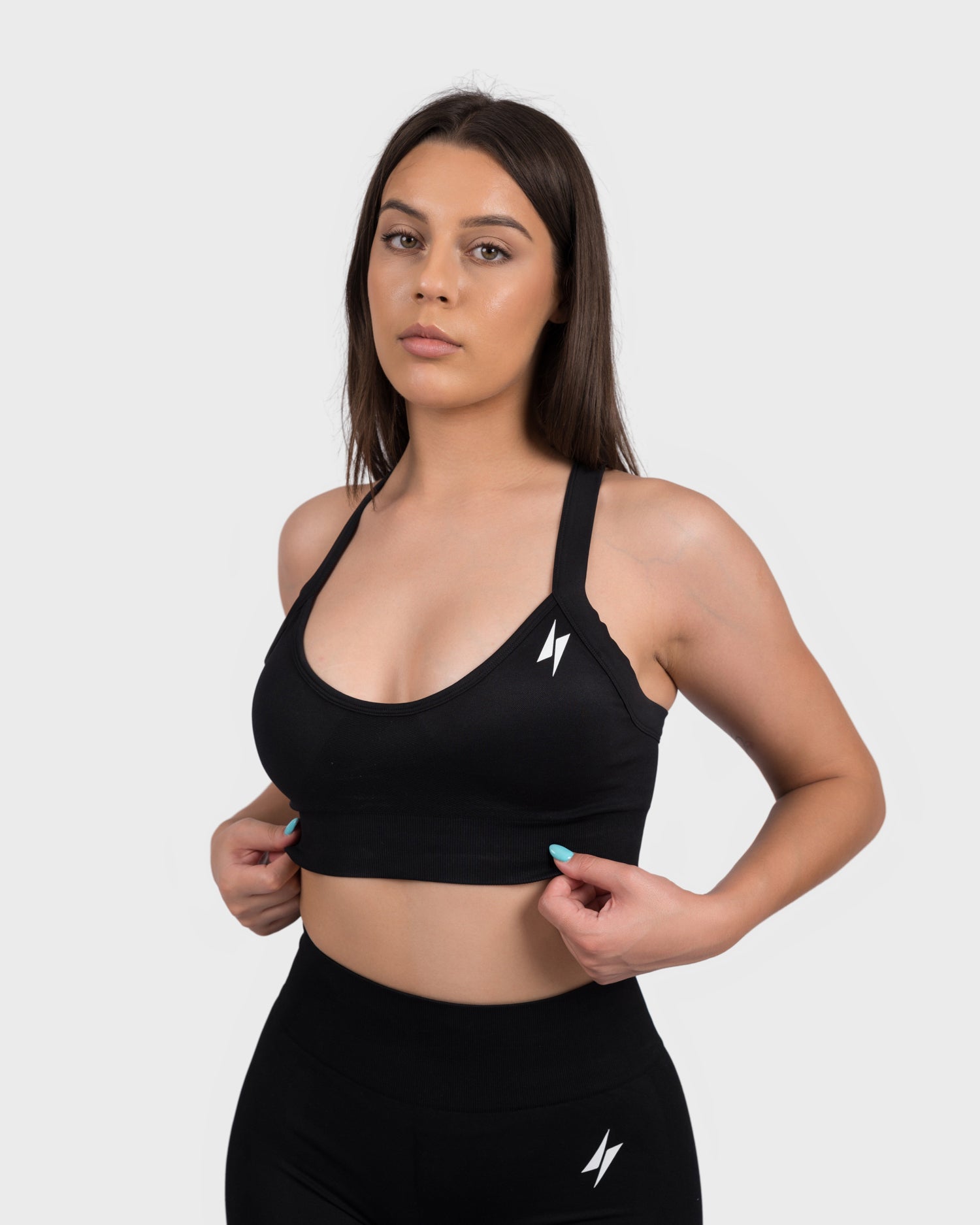 Black FlexActive Sports Bra, front angle with hand on waist, showing stretch and fit.