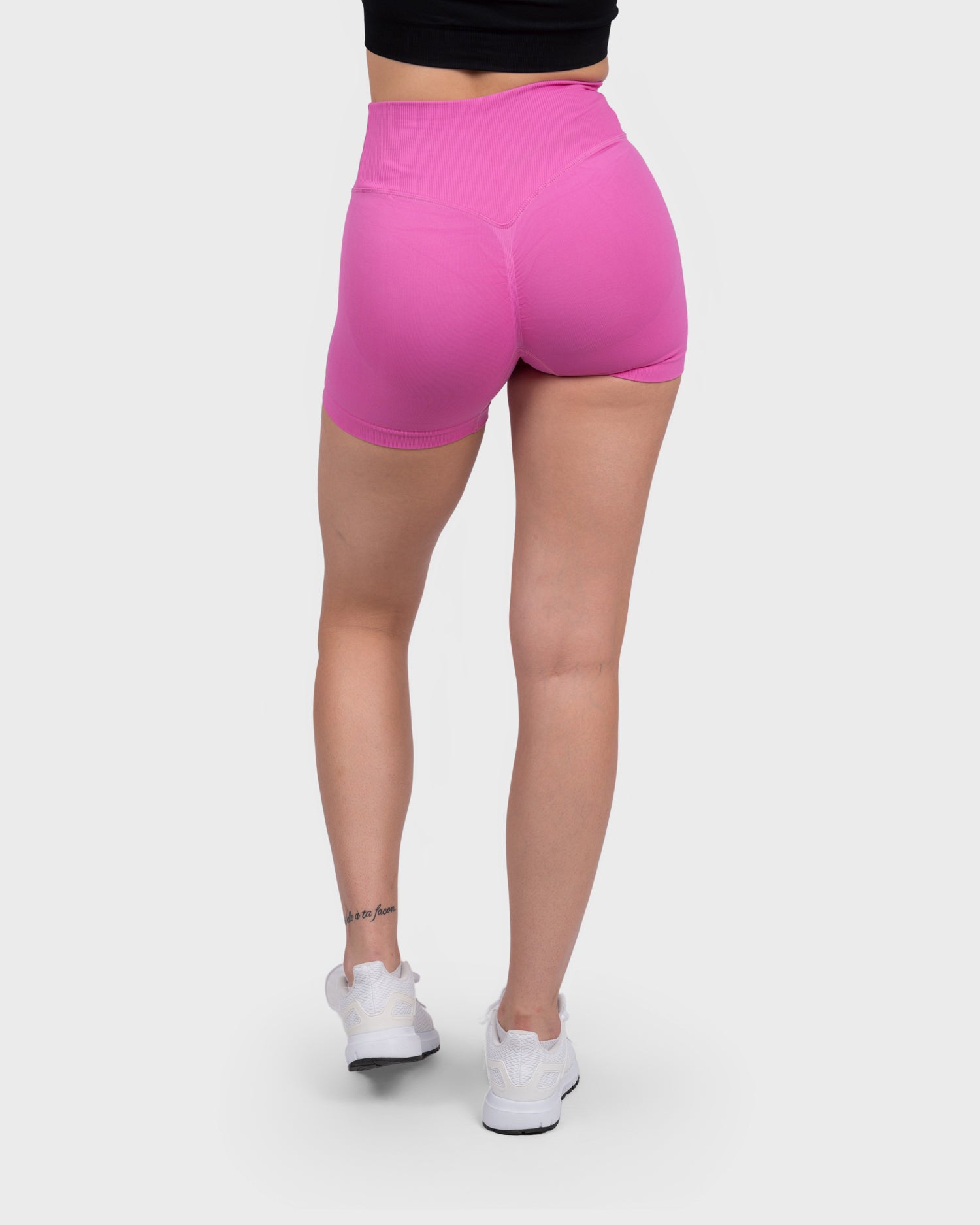 Back view of Evolve V-Sculpt Shorts in hot pink, seamless design and contour.
