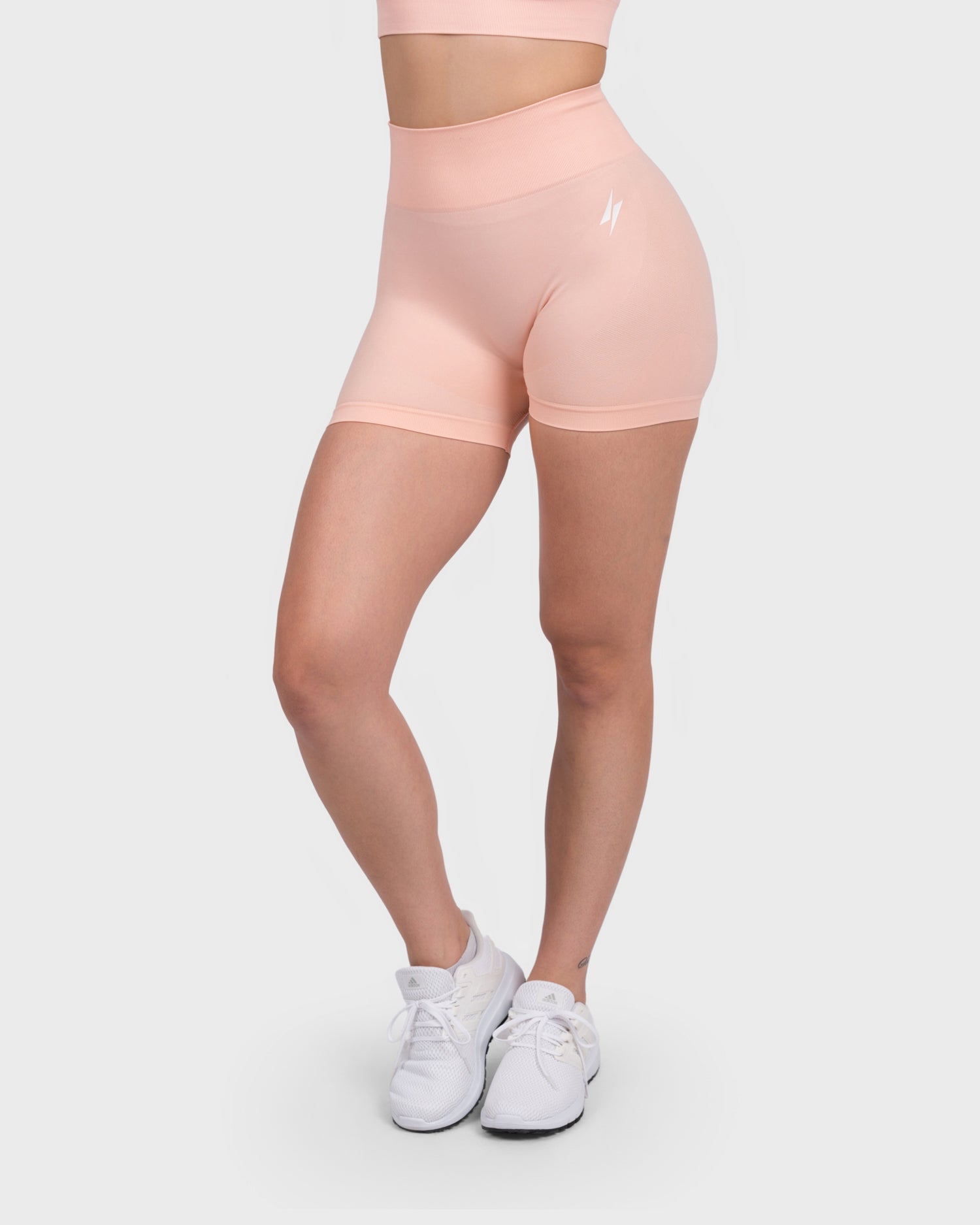 FlexActive High Waist Shorts from PWG Active in light peach, front view with logo detail.