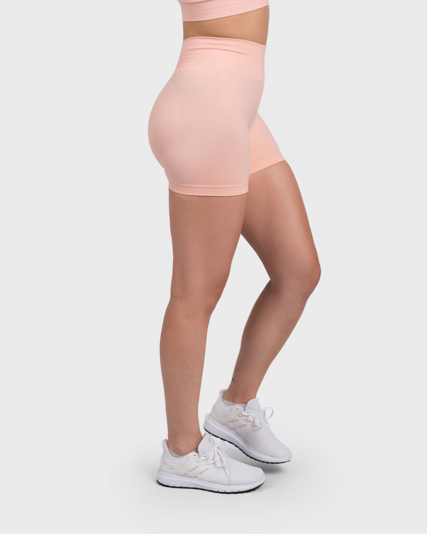 Rear angle of FlexActive Shorts in light peach, showcasing glute contour and stretch.