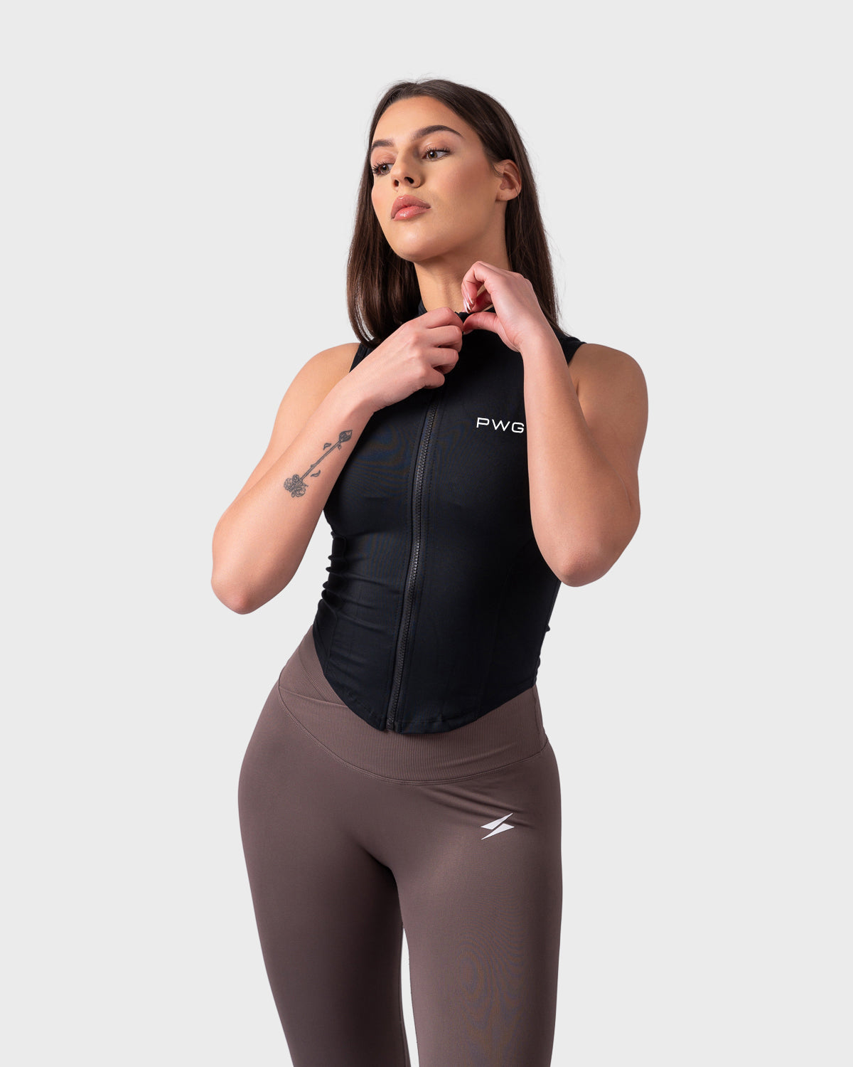 Relaxed stance in Evolve Sleeveless Jacket, hand near neck, showing sculpted shape.