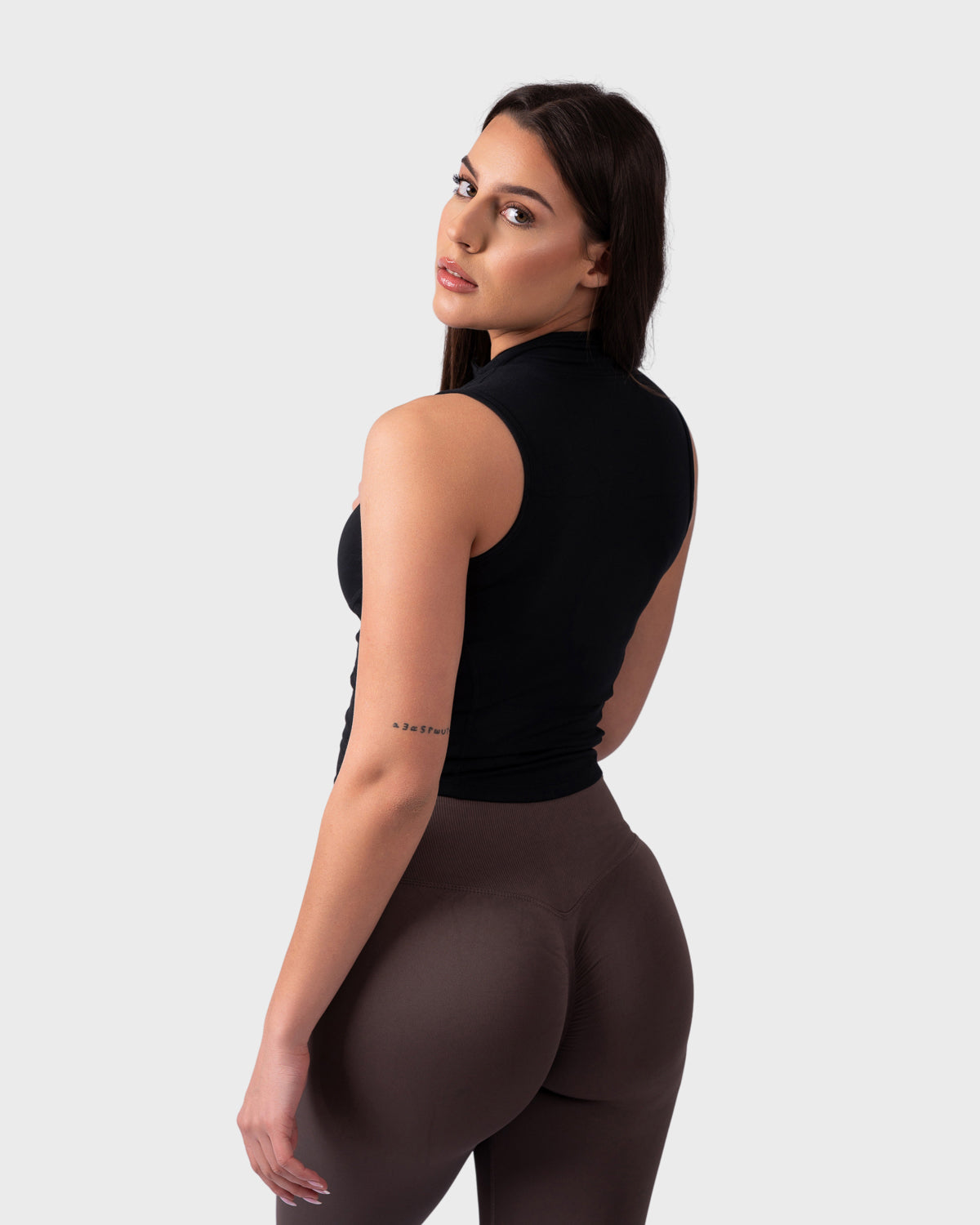 Rear view of Evolve Sleeveless Jacket in black, showcasing racerback cut and tapered fit.