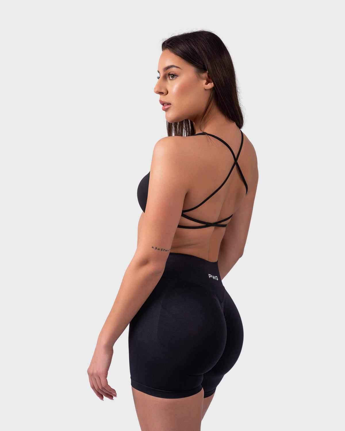 Rear angle of black backless bra with crisscross straps and sculpting shorts.