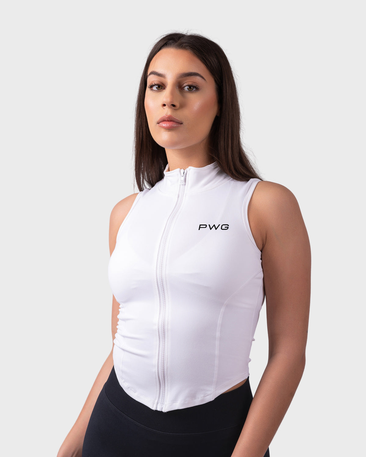 Full frontal pose in white sleeveless jacket, high collar and sculpted fit.