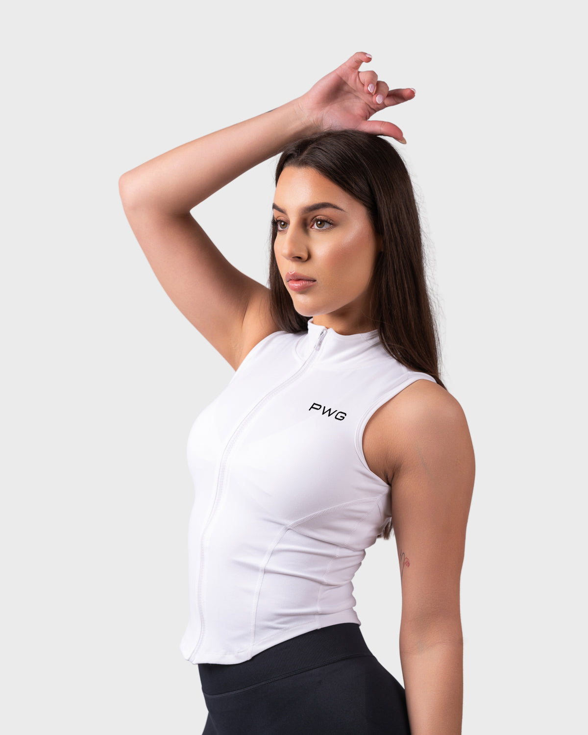 Relaxed pose with arm raised, showcasing fit and structure of sleeveless jacket.
