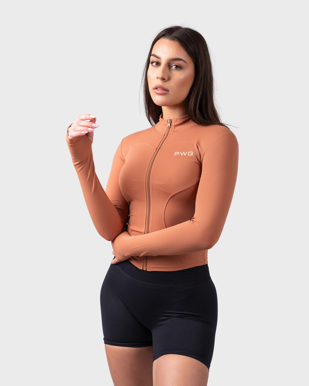 Evolve Sculpt Fit Jacket from PWG Active in caramel toffee, front view with thumbholes and zip.