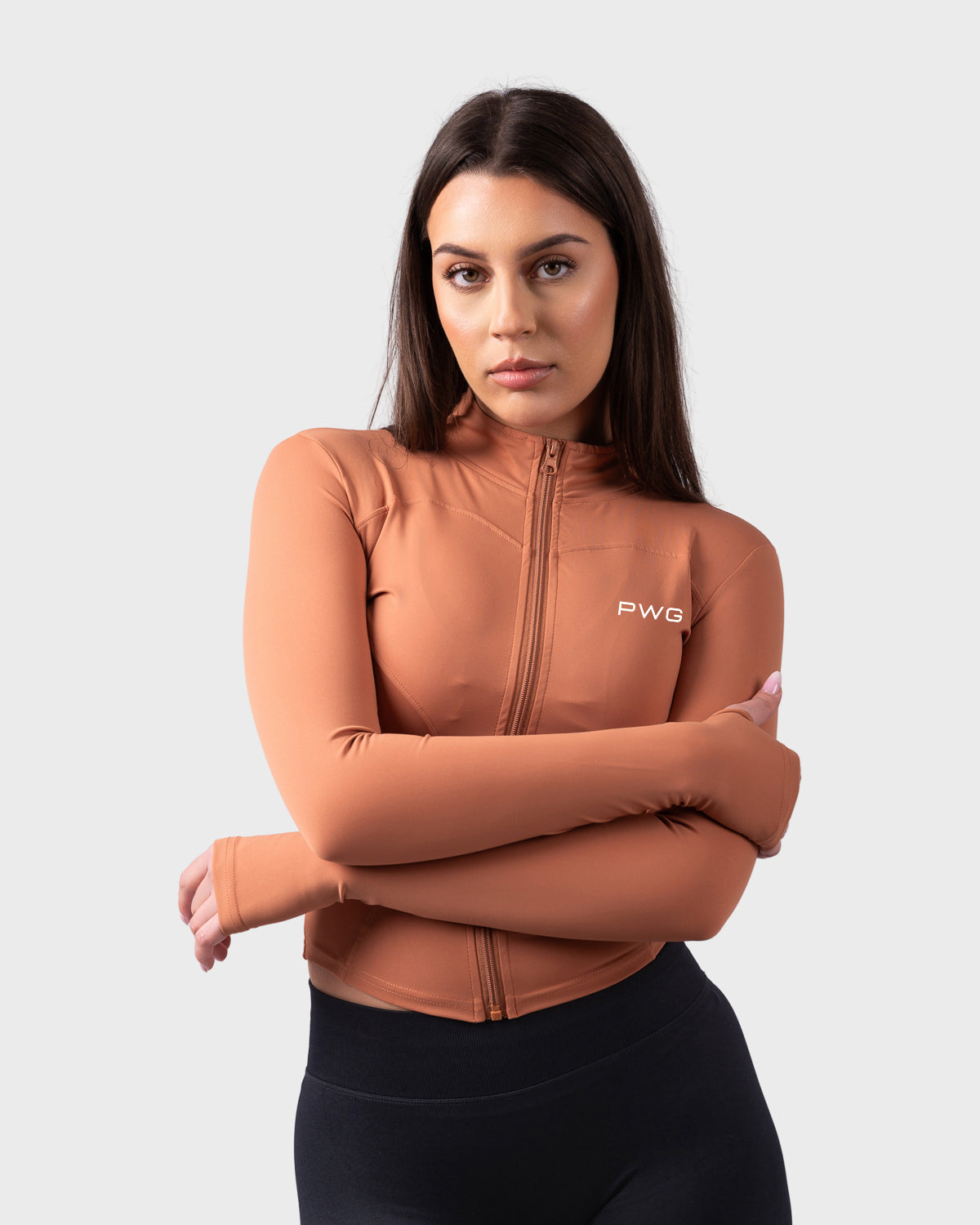 Front angle of Evolve Jacket with arms crossed, styled with black shorts.