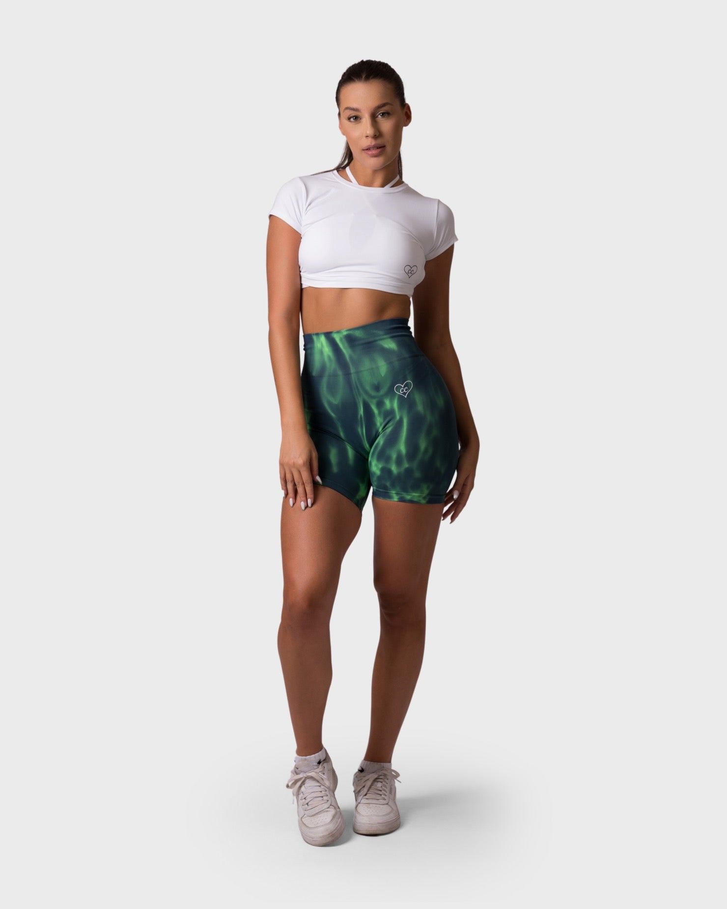 Full-body outfit featuring White top and matching tie-dye shorts, relaxed pose.