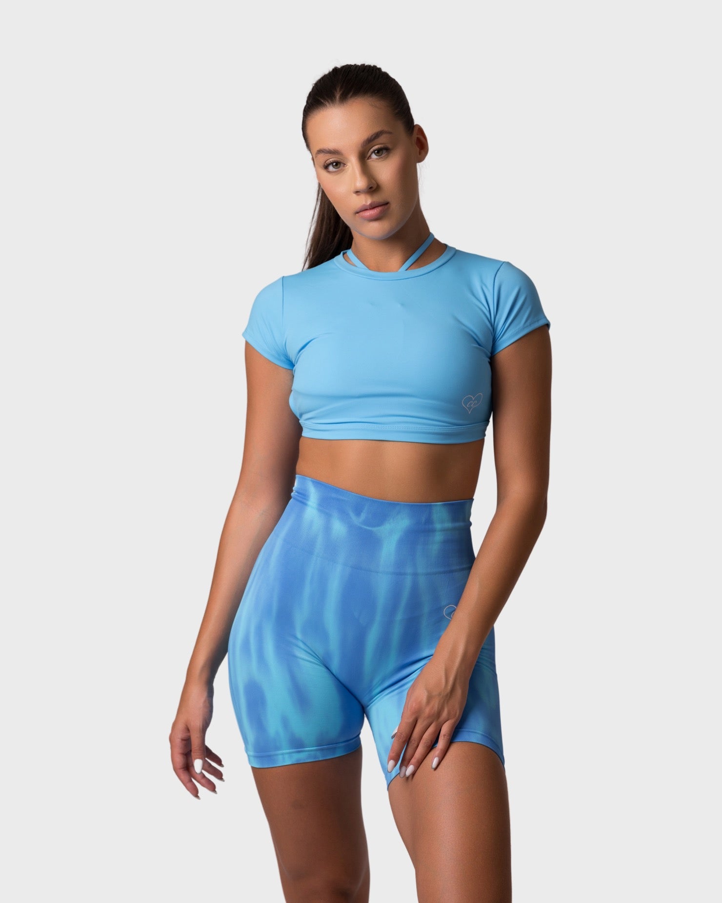 Full-body outfit featuring PWG x CC Short Sleeve Top in Ocean Blue and matching tie-dye shorts, relaxed pose.