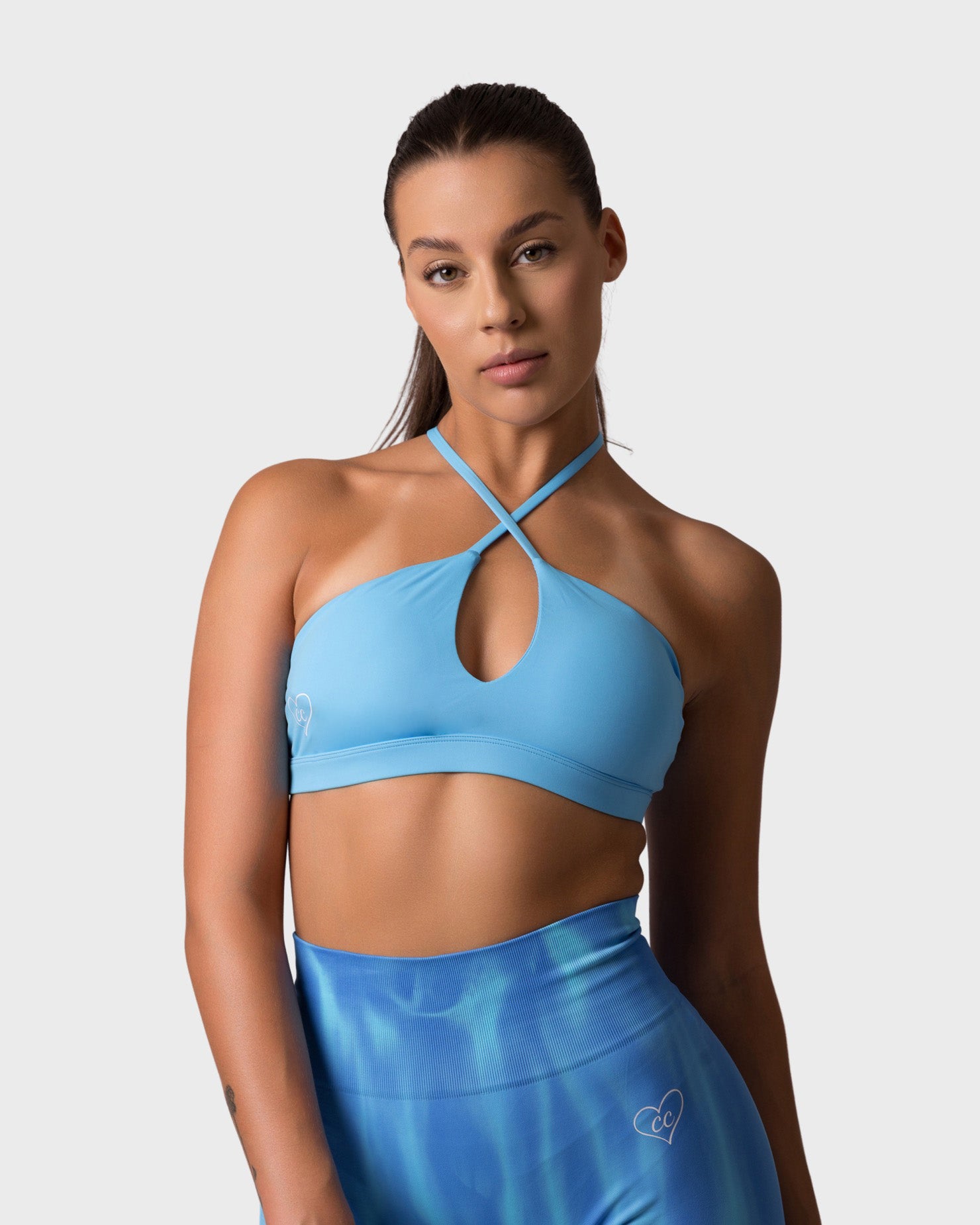 Front view of ocean blue sports bra with criss-cross halter neckline and keyhole detail.