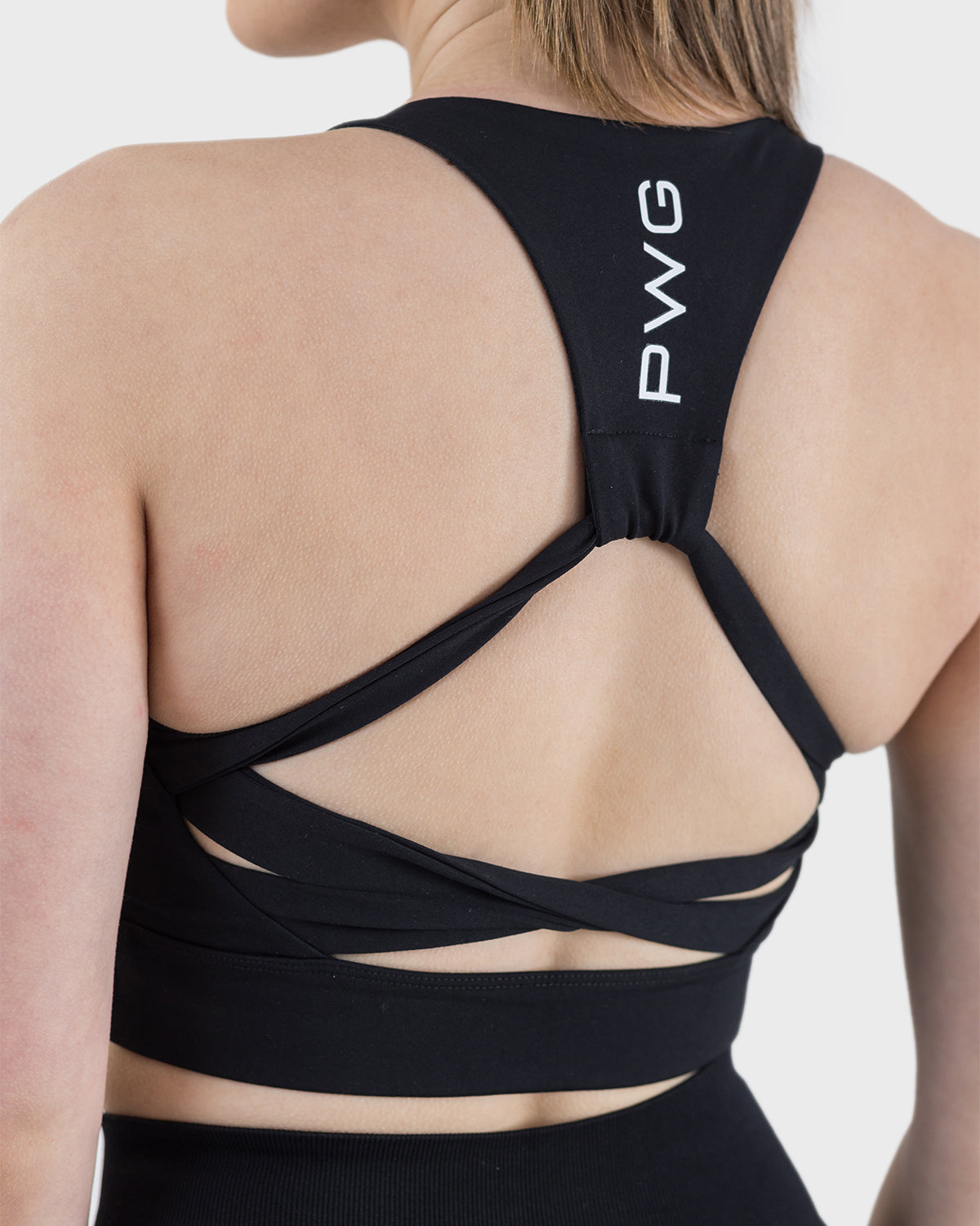 PWG Active Arise Sports Bra in Black, body fit, medium support, crossed back straps, plunge neckline, removable padding - Back View